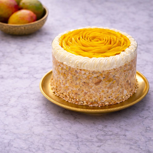 A premium fresh mango cake featuring a beautiful mango slice rose on top, creamy frosting, and crushed nut coating, handcrafted by Let's Bake Cake for summer celebrations in Abu Dhabi