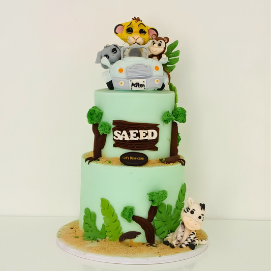 A premium two-tier mint green jungle safari themed birthday cake featuring 3D fondant animals in a car and a custom name plate 'SAEED' by Let's Bake Cake Abu Dhabi.